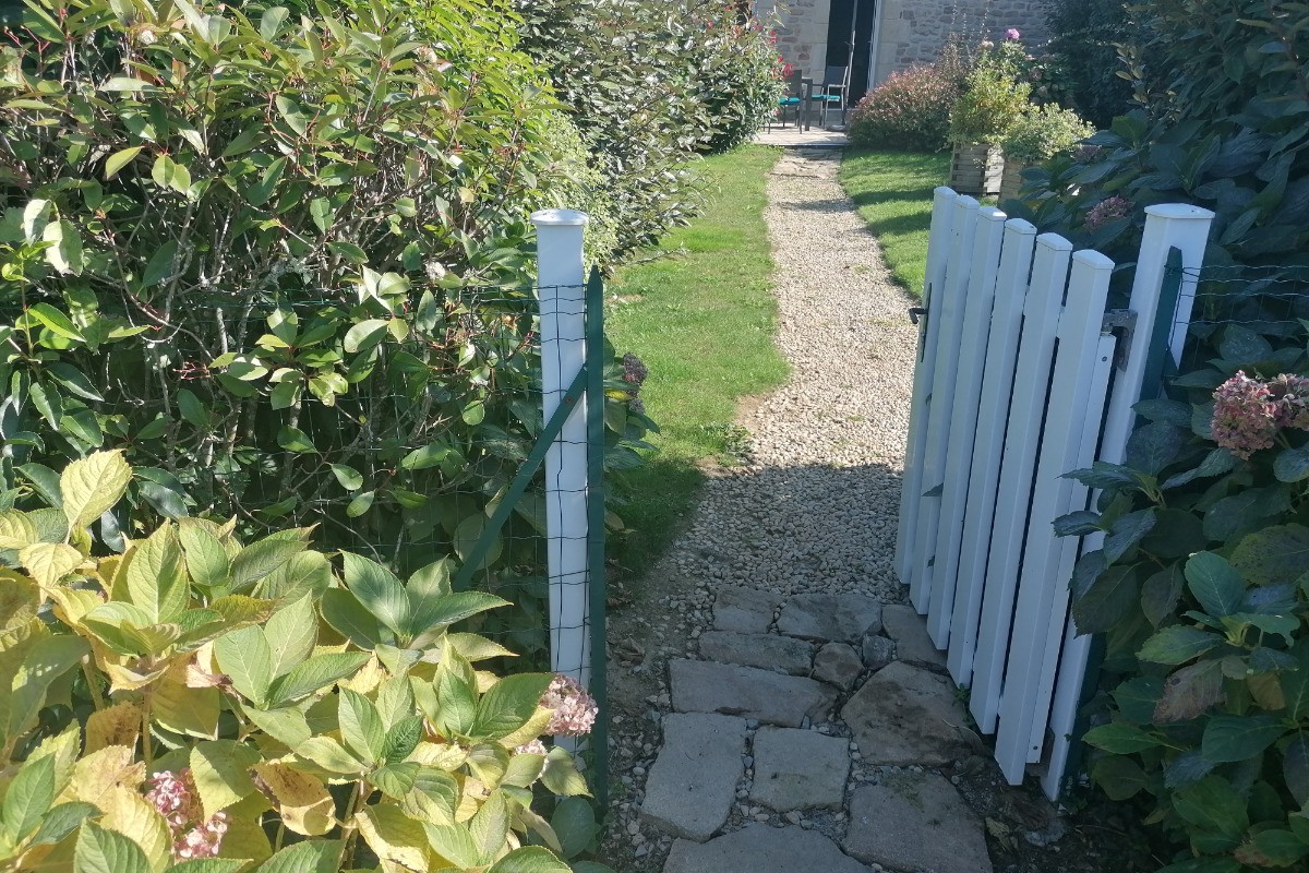 ROZAVEL: Entrée de votre jardin privé CLOS, à l'arrière: totalement clôturé d'un grillage,doublé d'une haie et fermé par un portillon.