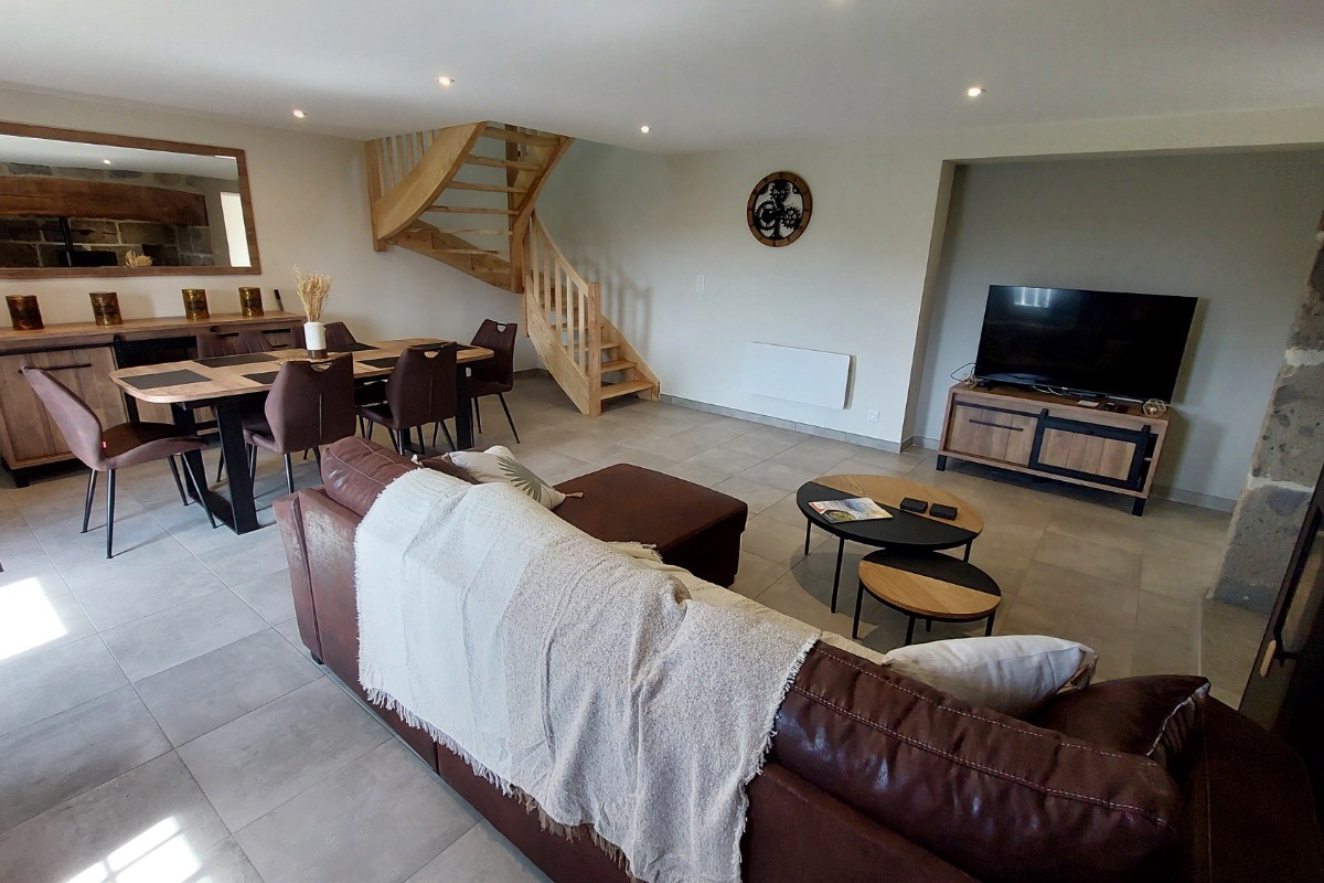 Grande pièce de vie du gîte La Petite Maison combinant salon cosy et salle à manger moderne.
