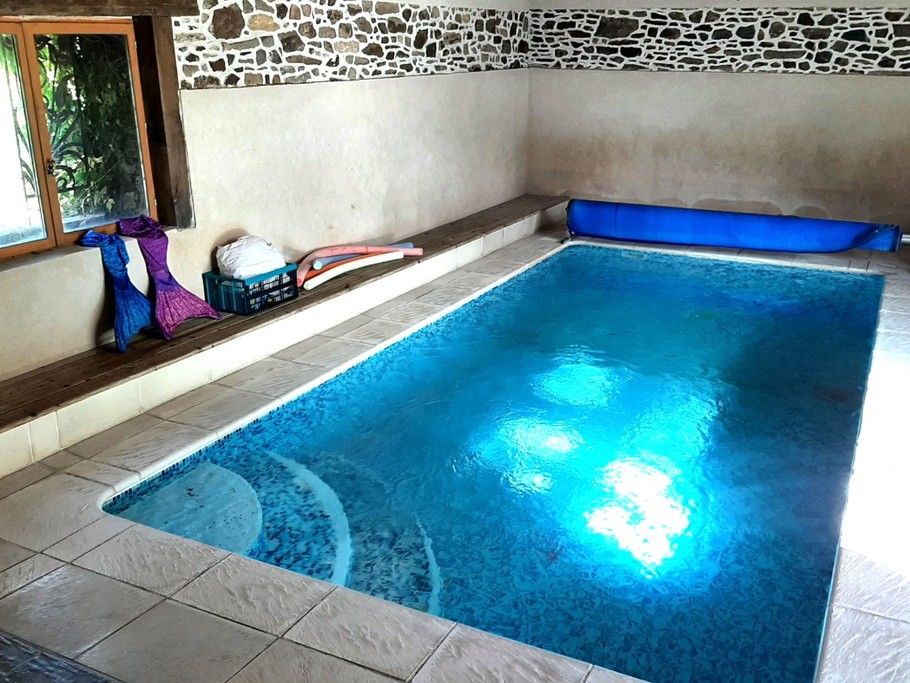 Piscine intérieure, commune à une autre gîte, avec espace sanitaire (douche, lavabo, WC).