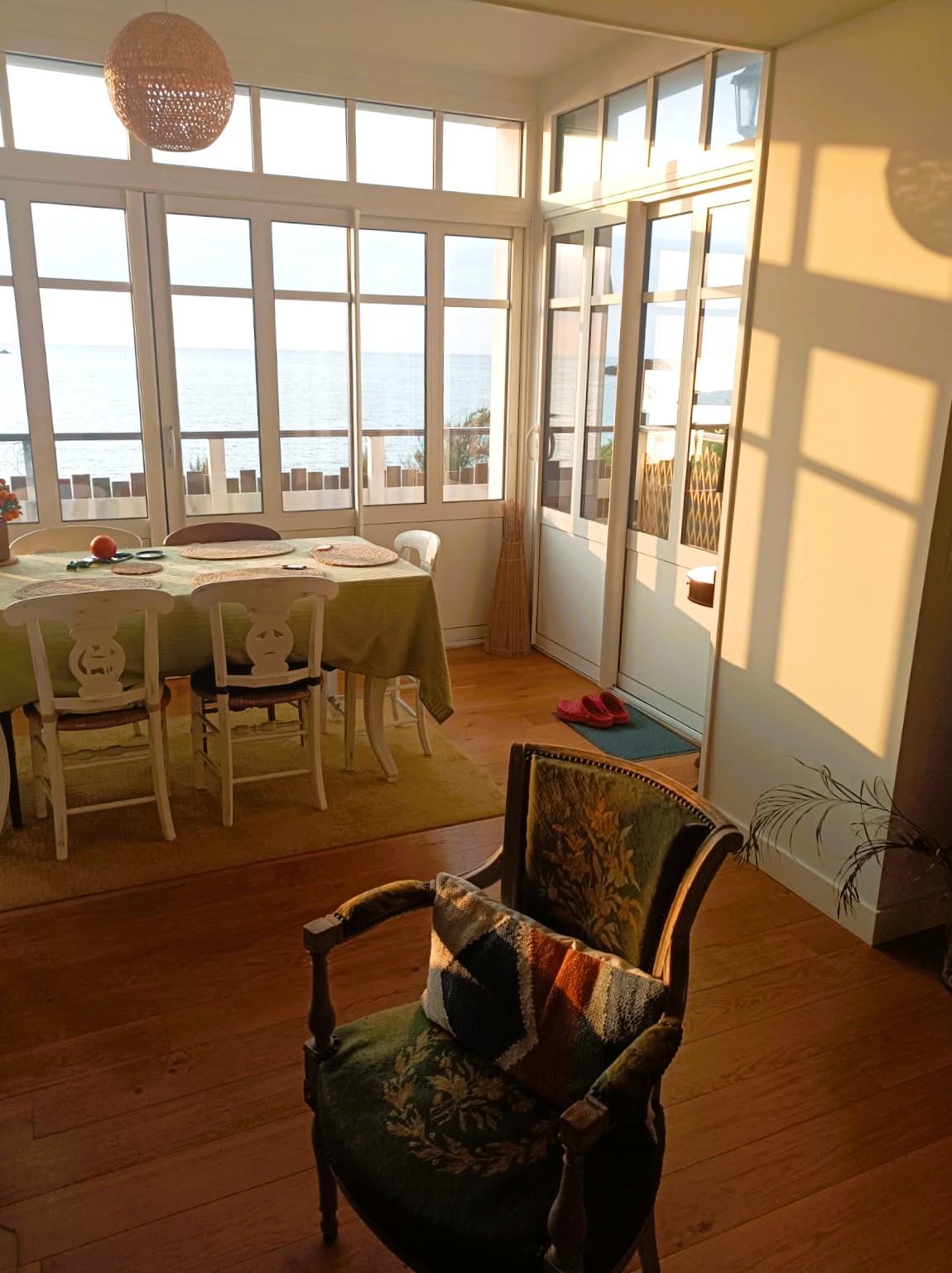 Grande pièce de vie avec 2 salons, un poêle à bois, un séjour dans la véranda vue mer.