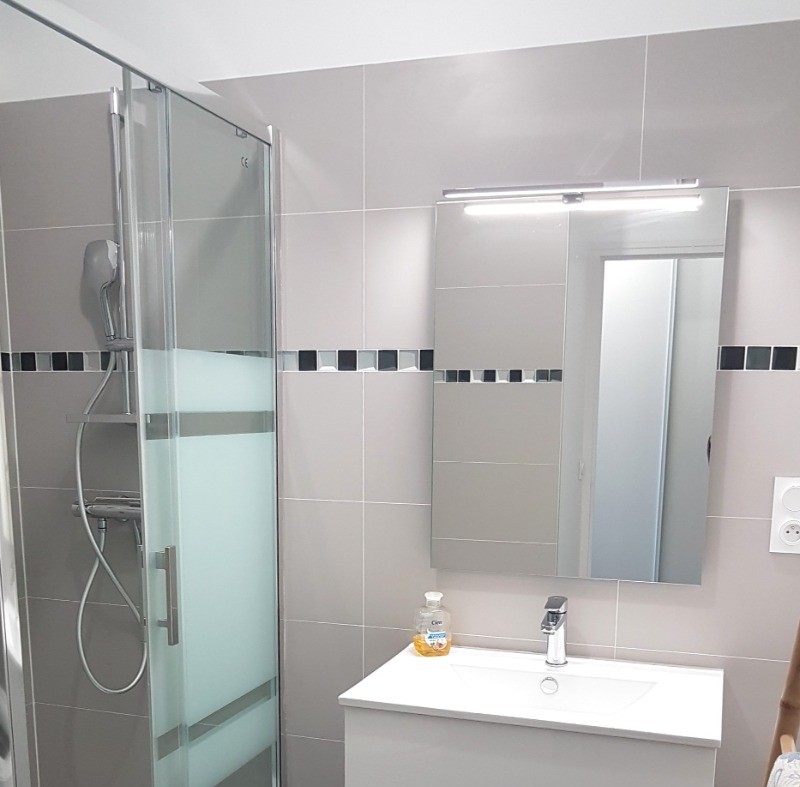 Salle d'eau avec une douche grande dimension, lavabo meuble vasque, machine à laver, sèche serviette électrique. WC séparé.