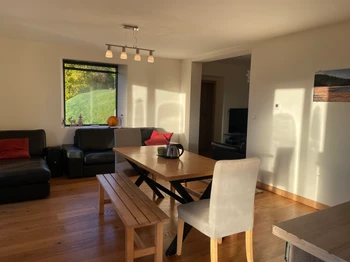 Large living room with open kitchen and TV lounge, view of lake and garden, south-facing