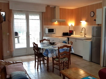 Pièce de vie au RDC avec coin cuisine et coin salon.