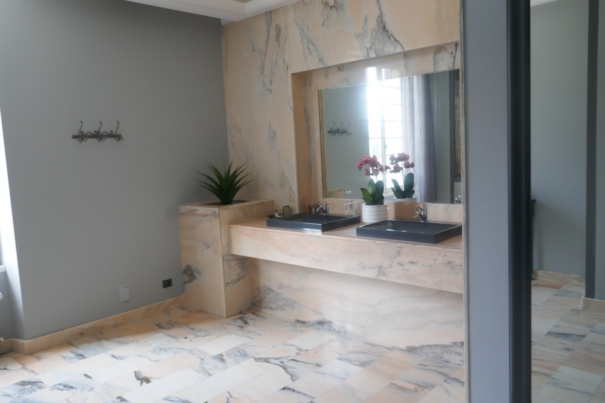 Salle de bain avec baignoire balnéo et douche