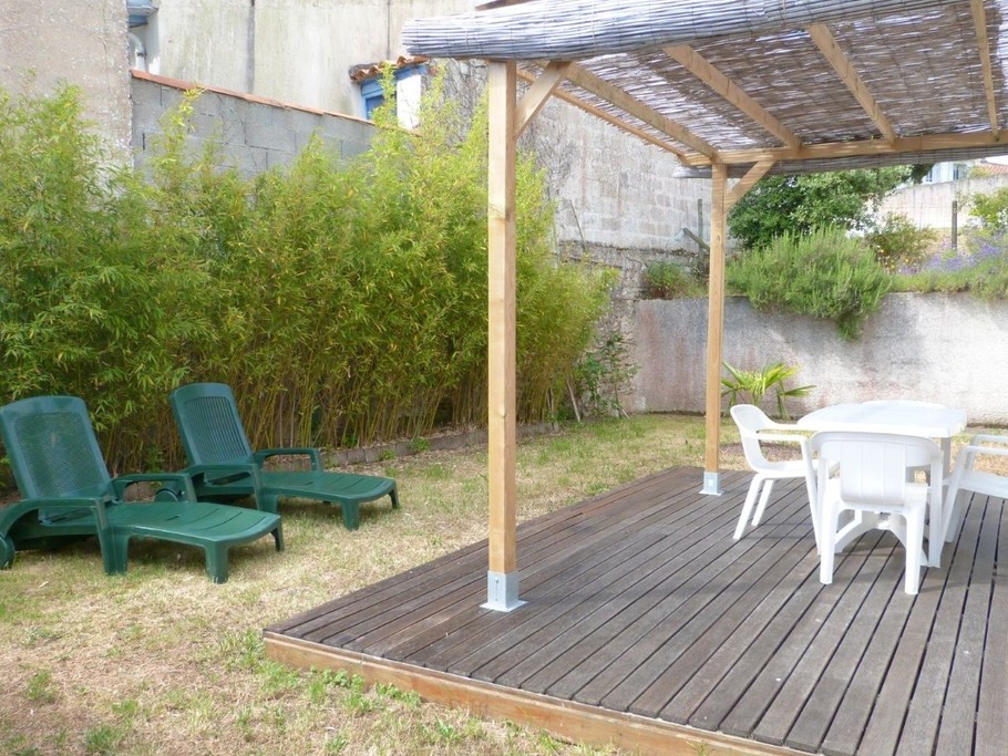 Terrasse en bois avec salon de jardin et bains de soleil