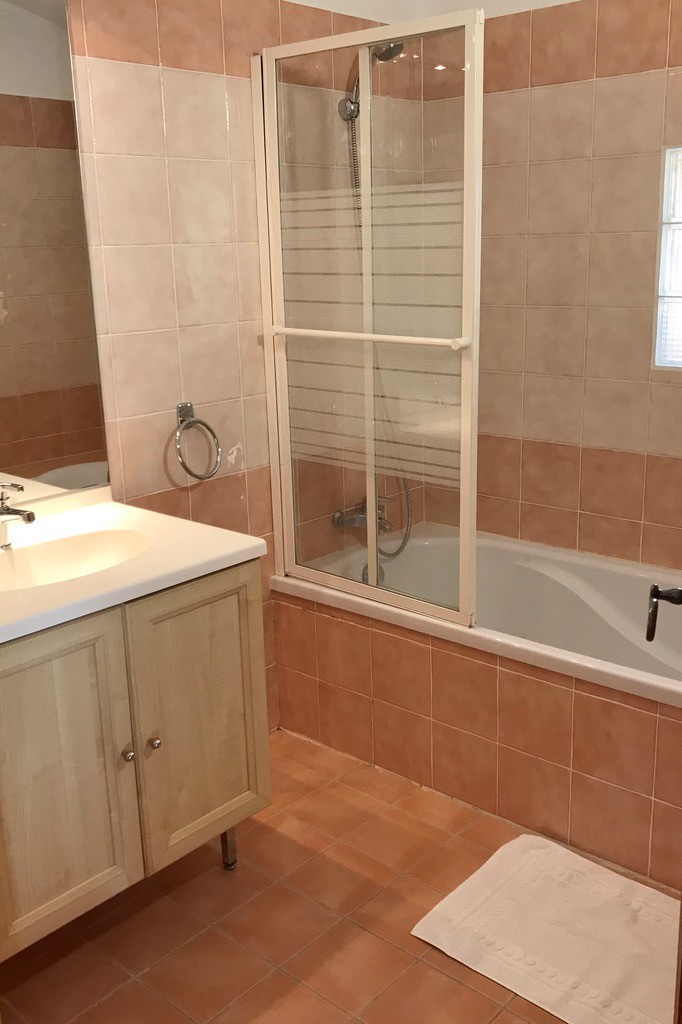 Salle de bains avec baignoire et pare-douche