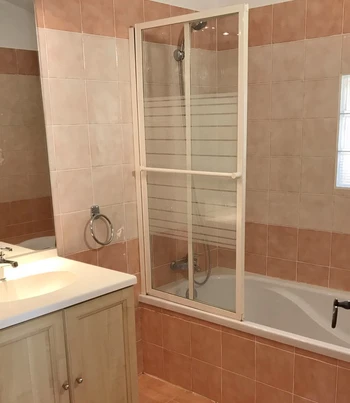 Salle de bains avec baignoire et pare-douche