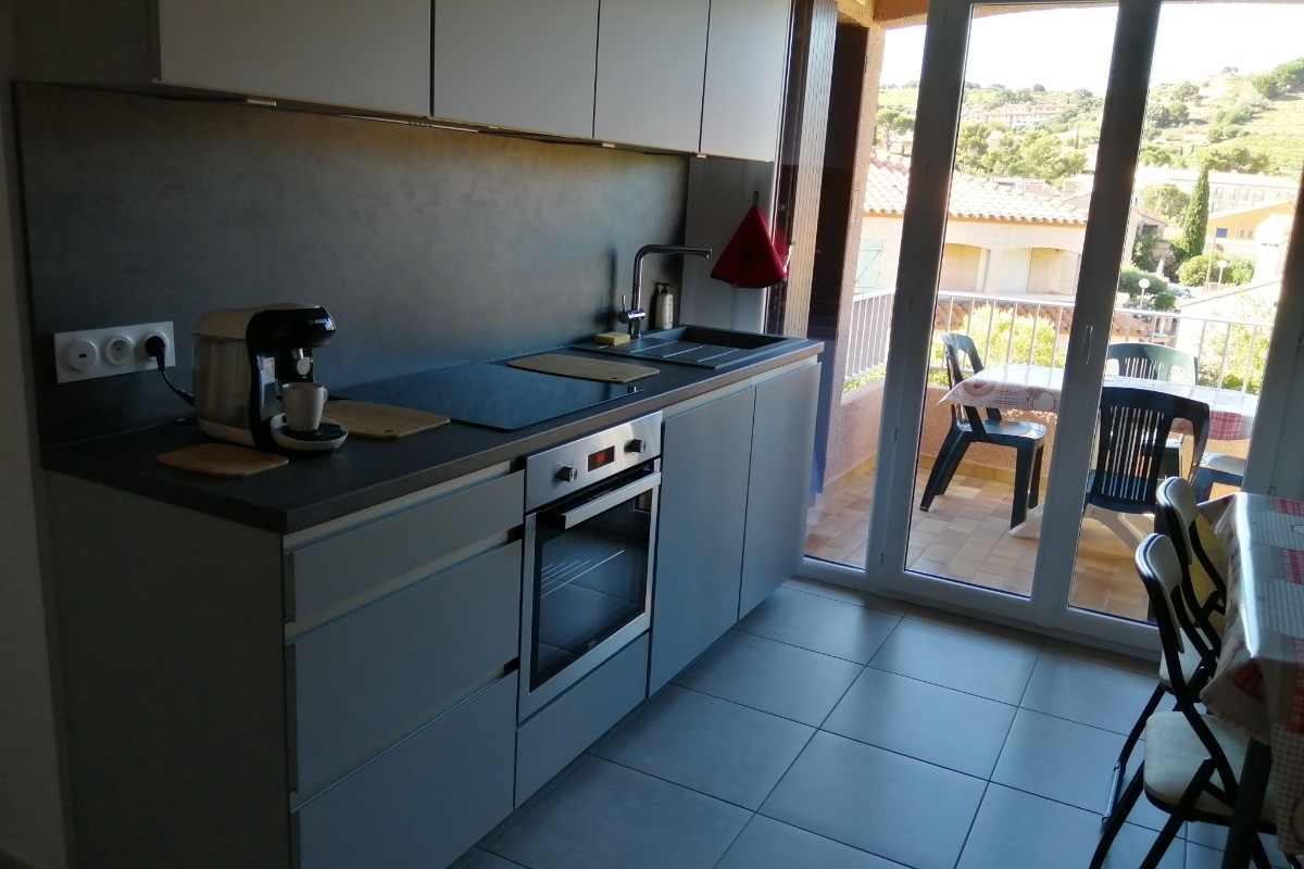 coin cuisine dans pièce à vivre avec accès à la terrasse