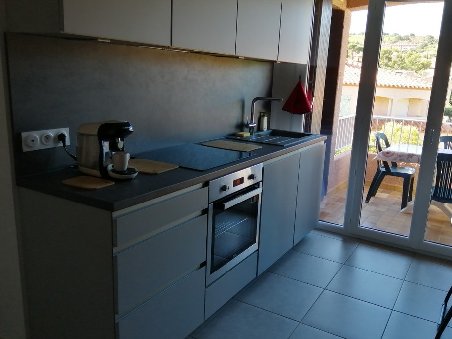 coin cuisine dans pièce à vivre avec accès à la terrasse