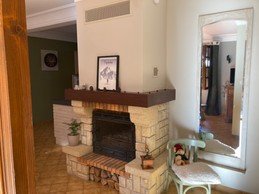 Cheminée au centre de la pièce de vie, espace repas, salon et hall d'entrée (vue sortie du hall d'entrée)