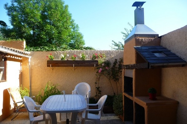 Cour avec salon de jardin et barbecue