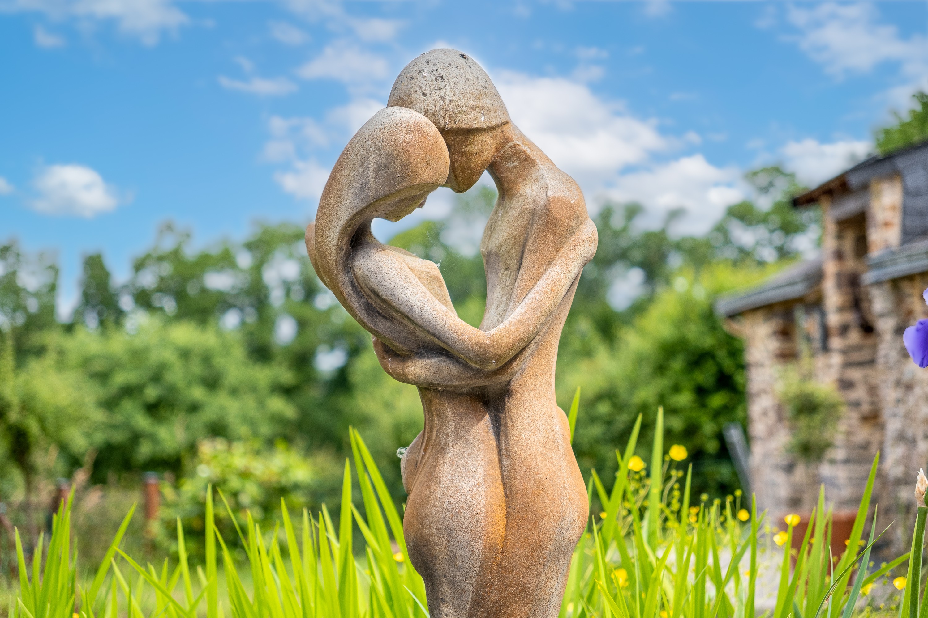 Sculpture sur le domaine, avec en arrière plan le gîte du Val