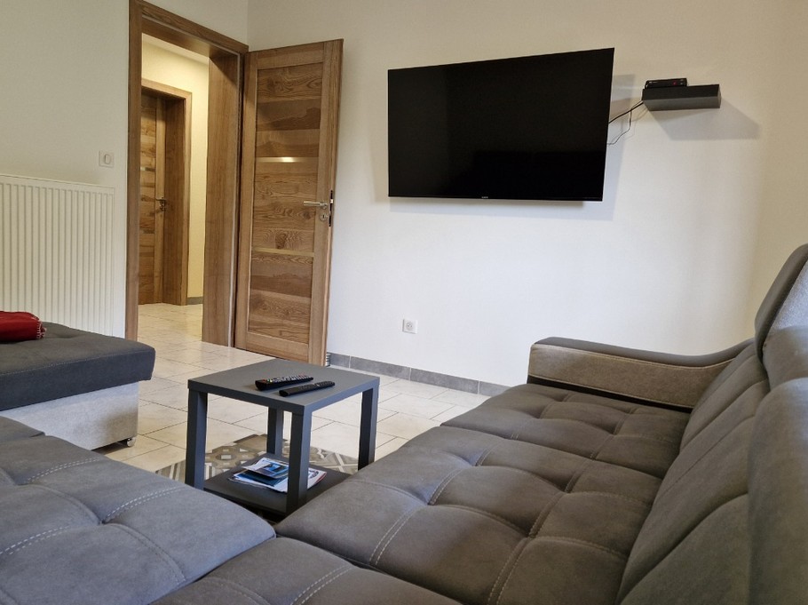 Salon avec canapé panoramique et TV - Gîte de la Haute Hardoye (14 pers) dans les Vosges