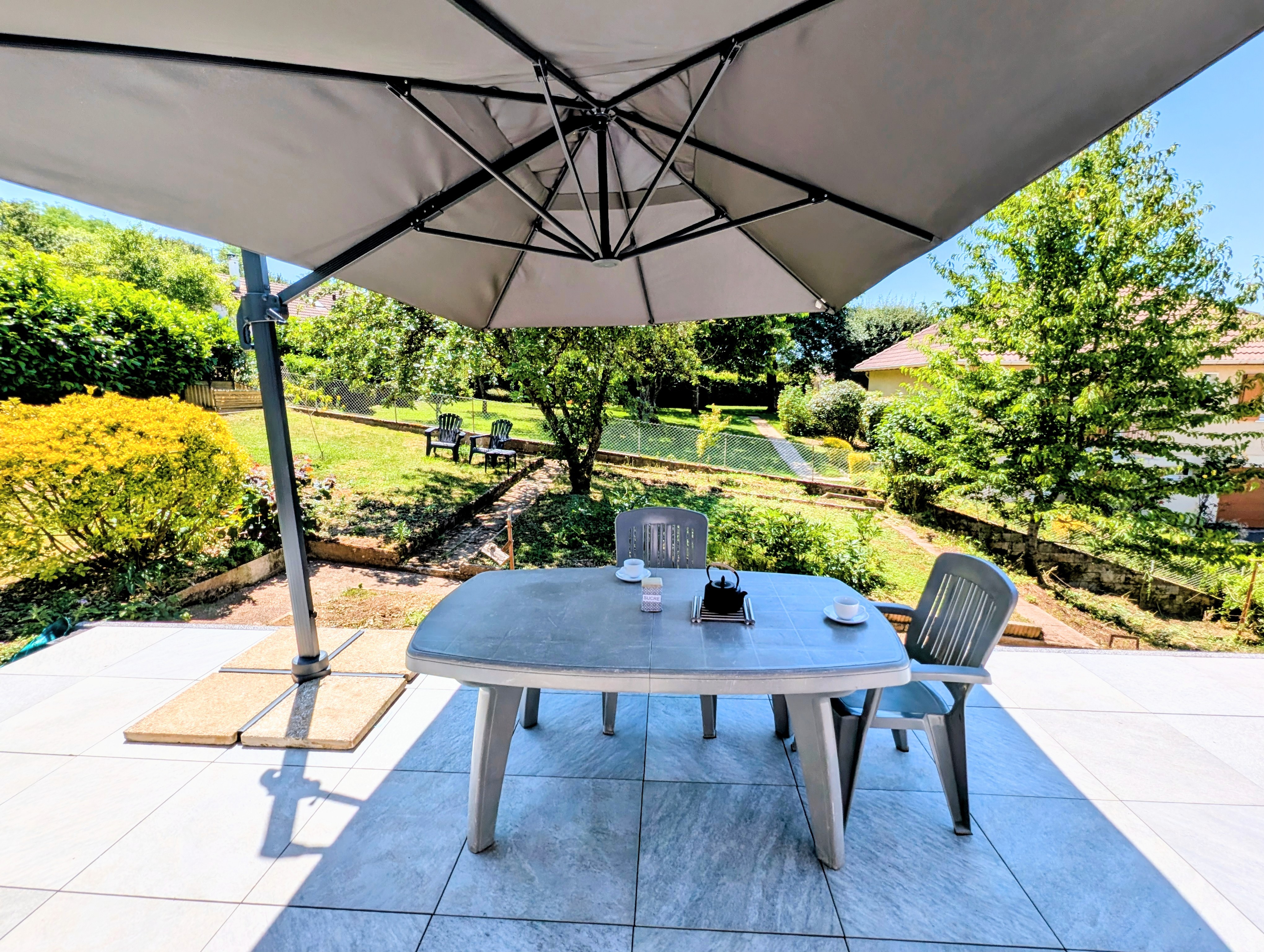 Thé ou café sur la terrasse à l'ombre avec vue sur le jardin