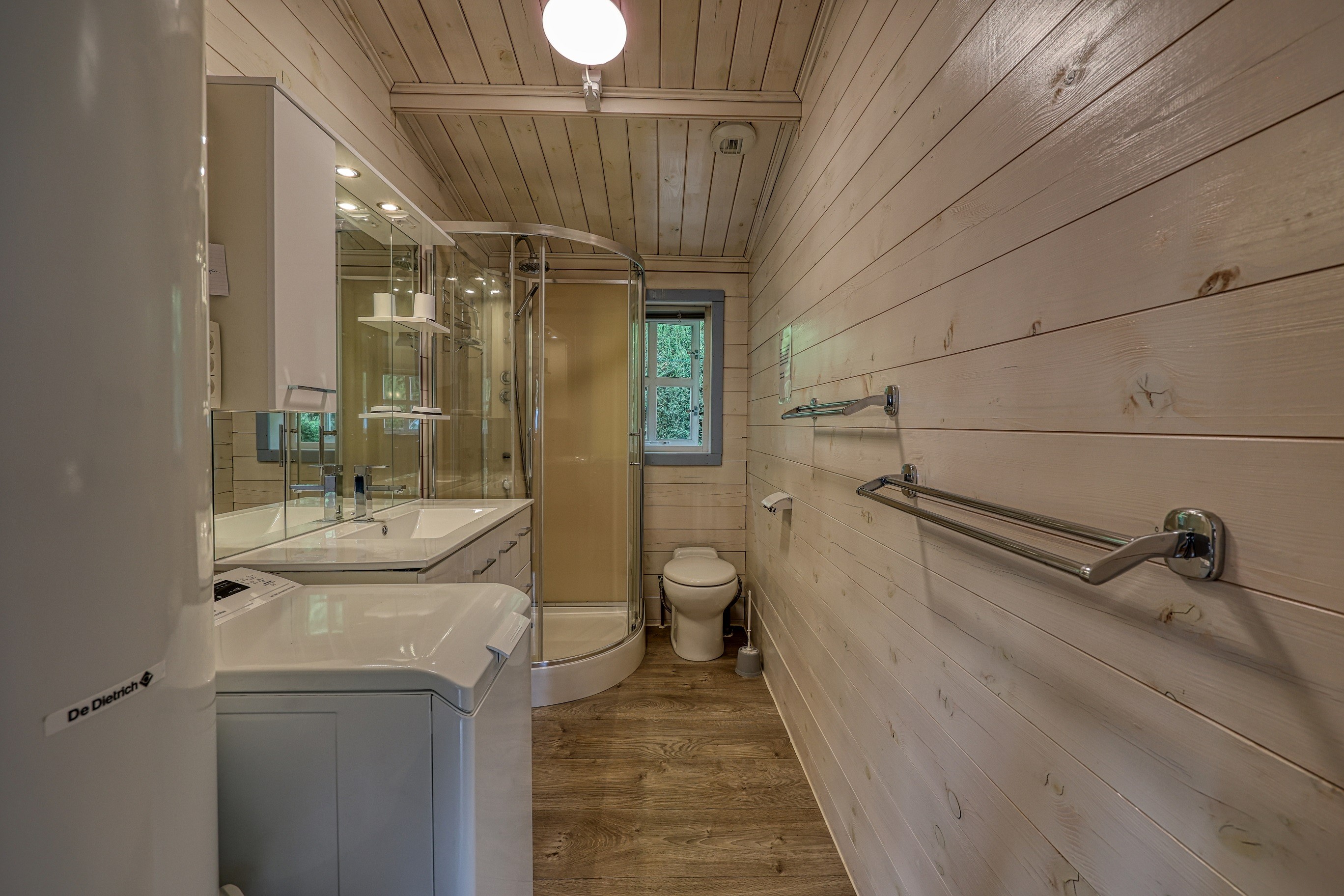 Salle de bain avec douche et lave-linge dans gîte de vacances