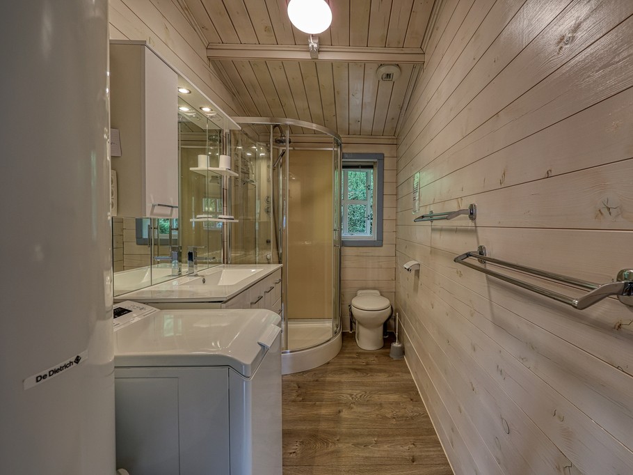 Salle de bain avec douche et lave-linge dans gîte de vacances