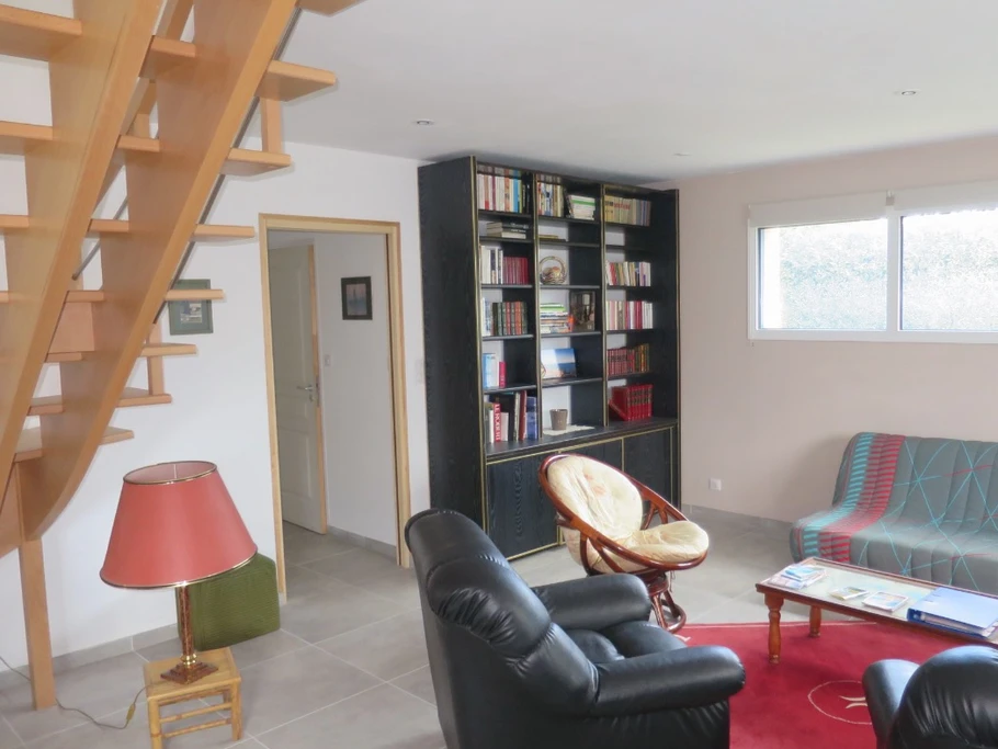 coin salon rdc avec grande bibliothèque à disposition