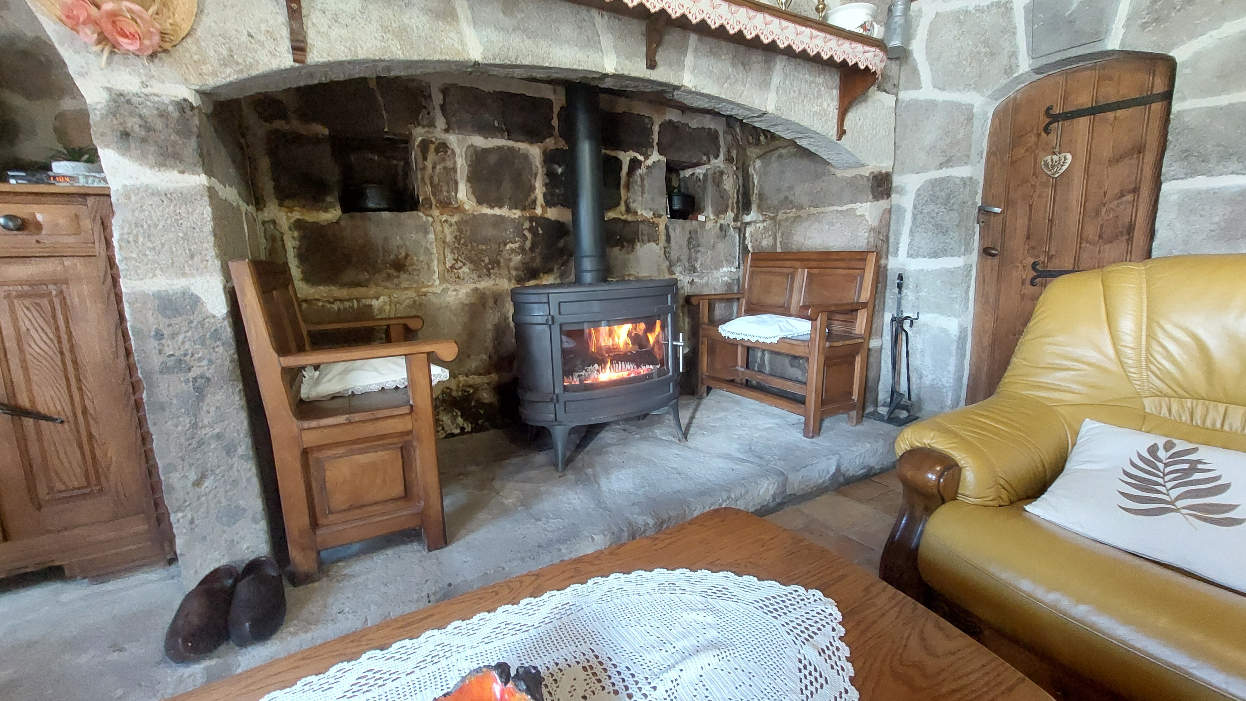 Detail of fireplace with wood fire in a traditional Auvergne house