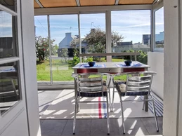 Grande véranda en façade de la maison donnant sur un grand jardin clos