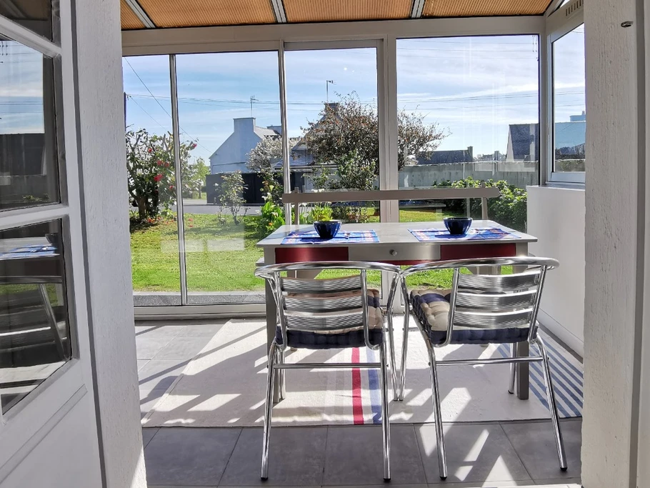 Grande véranda en façade de la maison donnant sur un grand jardin clos