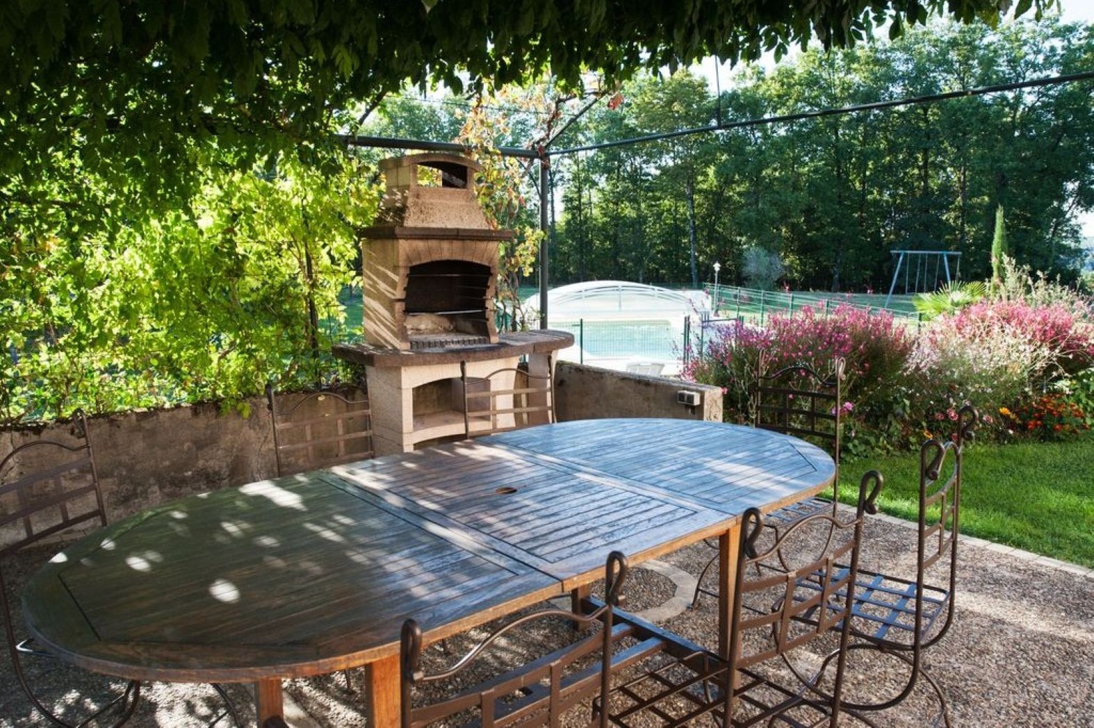 Salon de jardin sous pergola végétalisée