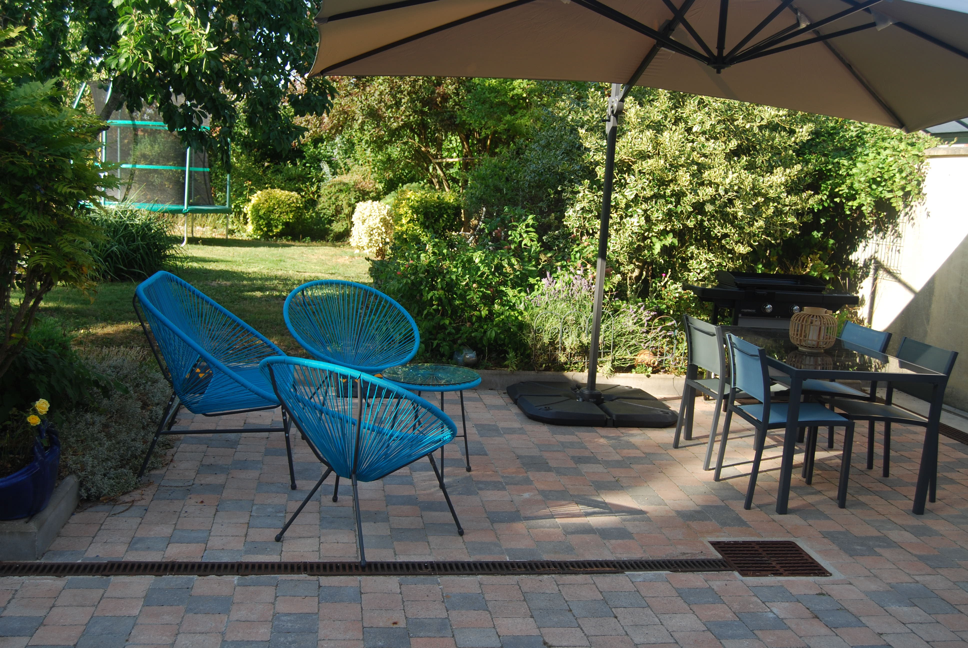 Terrasse équipée de mobilier de jardin pour repas en plein air