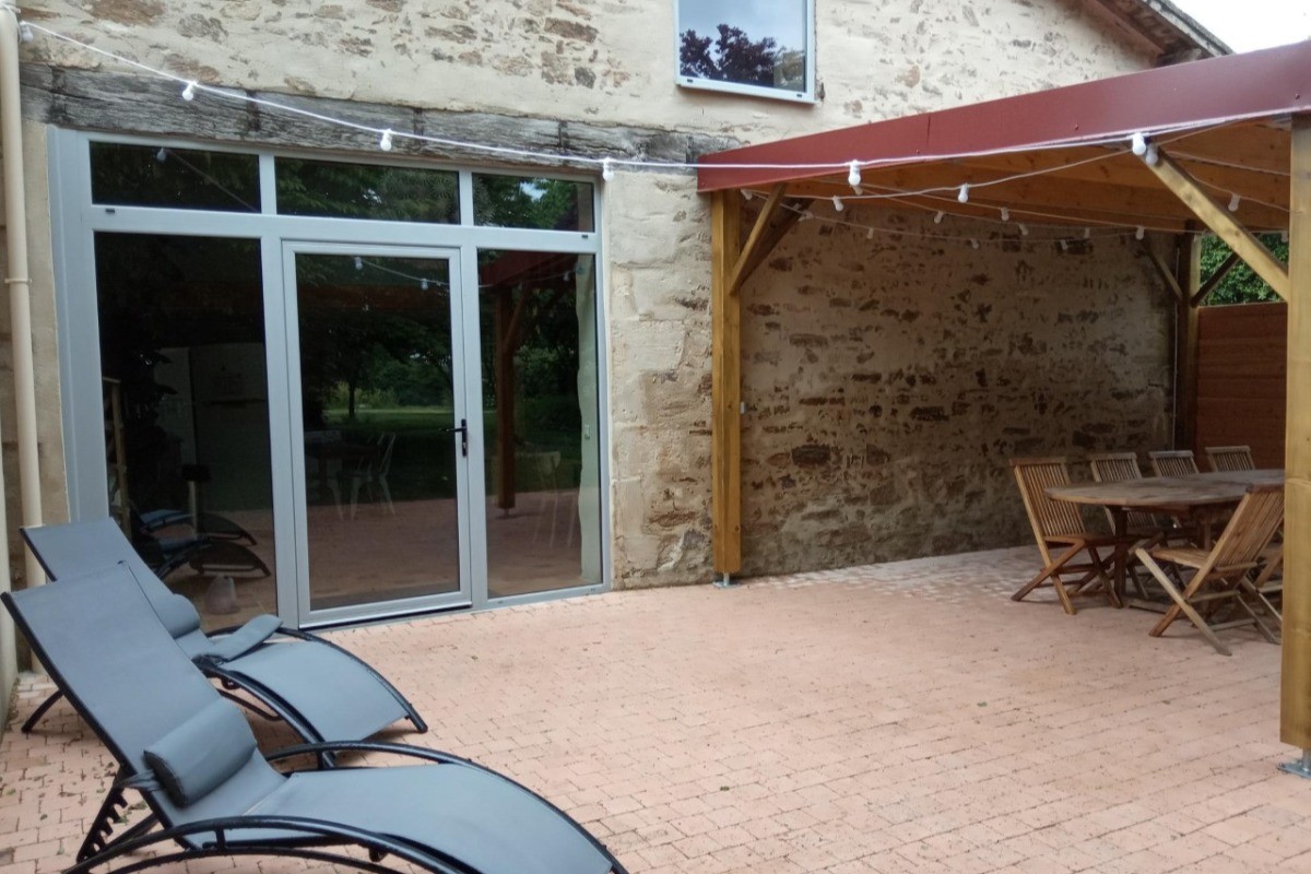 Terrasse pavée avec pergola illuminée le soir