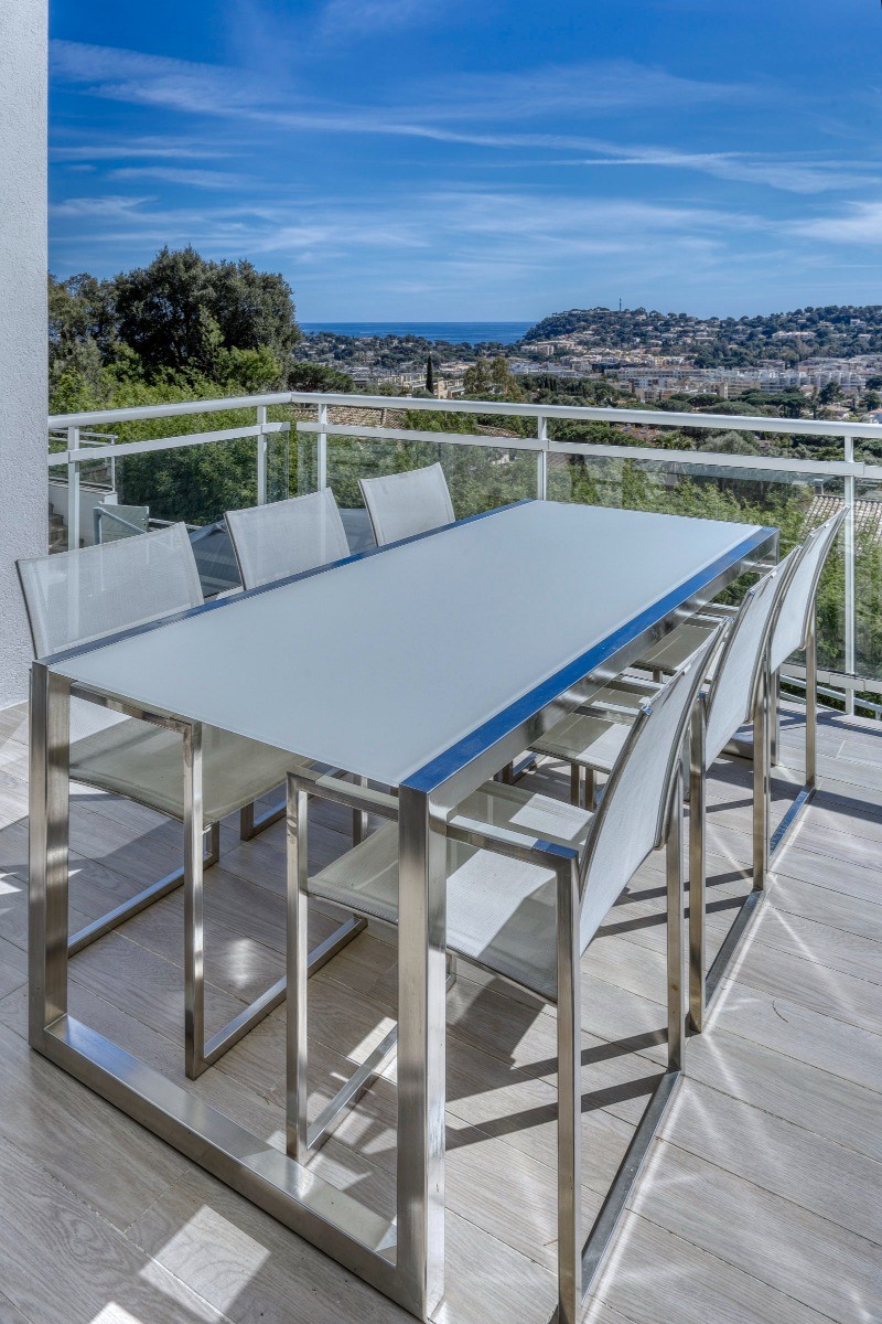 Coin repas (8 places disponibles) sous pergola sur balcon extérieur en prolongement de la cuisine avec vue mer panoramique