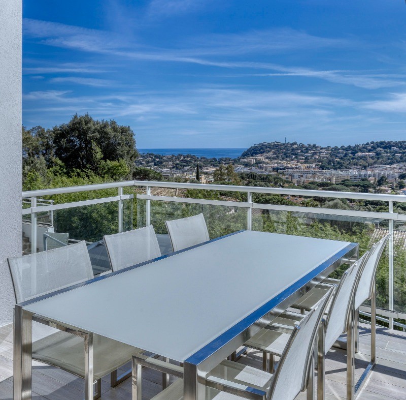 Coin repas (8 places disponibles) sous pergola sur balcon extérieur en prolongement de la cuisine avec vue mer panoramique