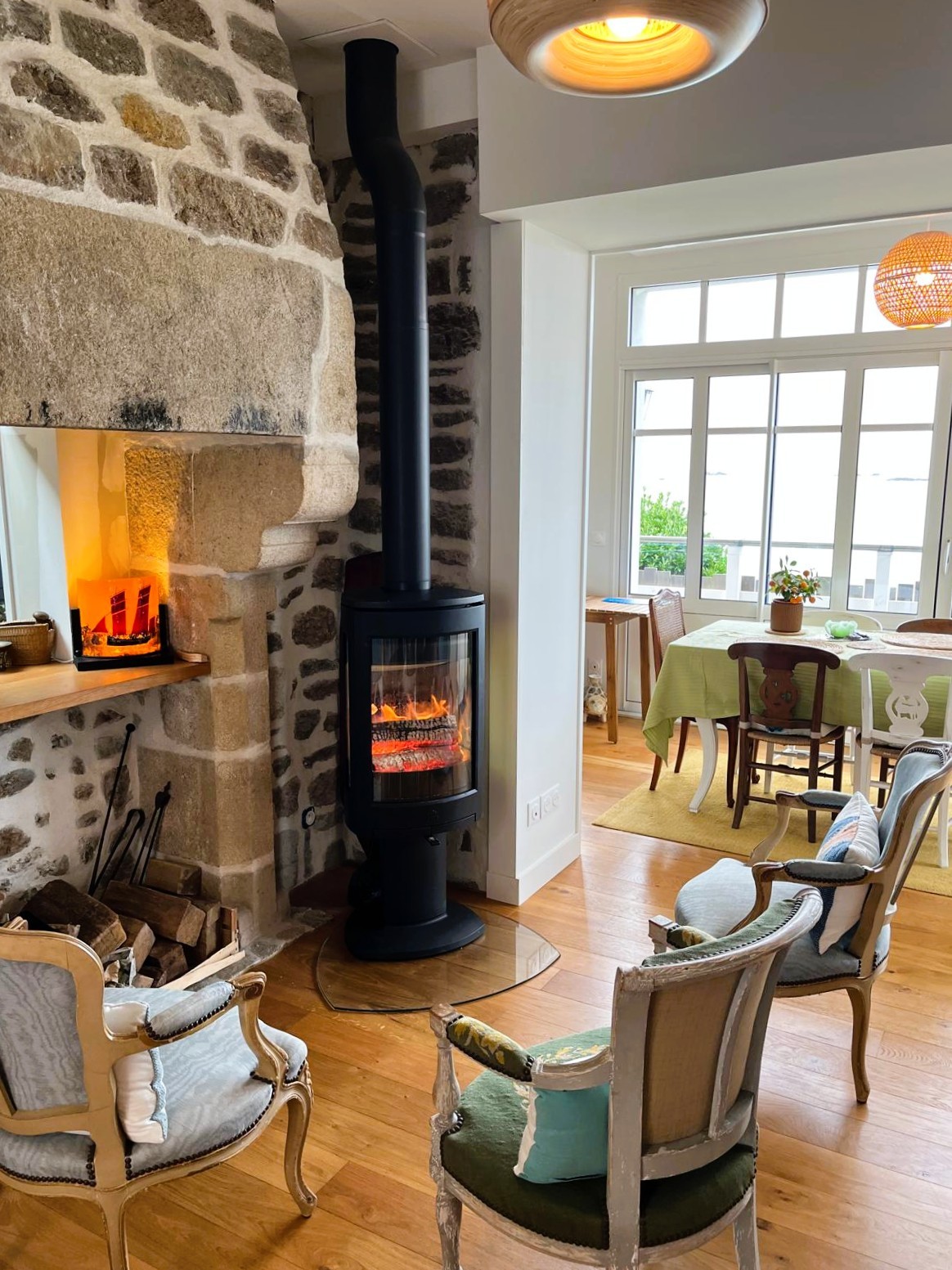 Grande pièce de vie avec 2 salons, un poêle à bois, un séjour dans la véranda vue mer.