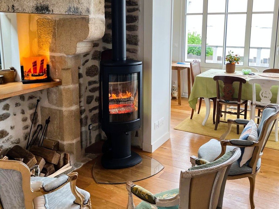 Grande pièce de vie avec 2 salons, un poêle à bois, un séjour dans la véranda vue mer.