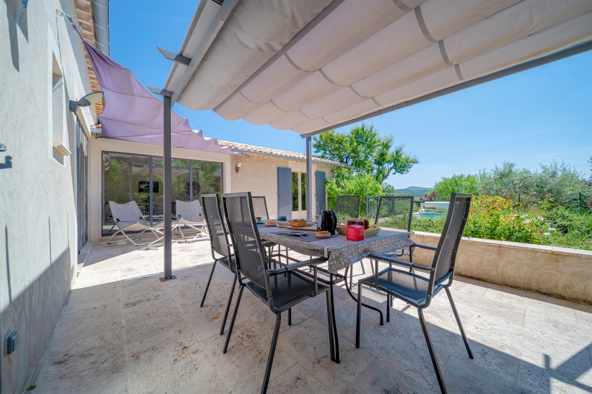 De la terrasse vue sur la piscine et au loin les montagnes du Luberon
