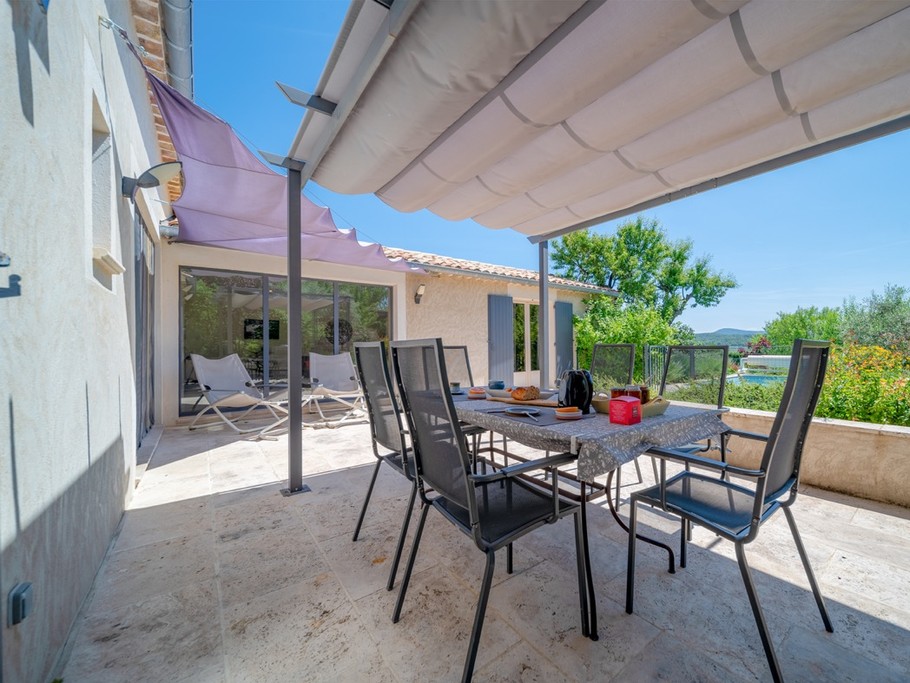 De la terrasse vue sur la piscine et au loin les montagnes du Luberon