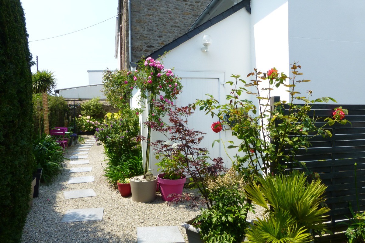 Allée fleurie menant à l'entrée de l'appartement situé au 1er étage.