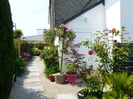Flowered driveway leading to the entrance to the flat on the 1st floor.