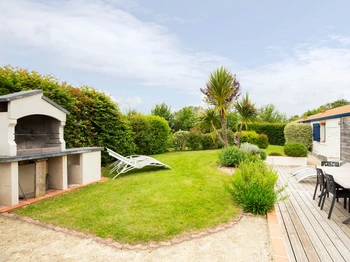 Jardin privatif avec terrasse, salon de jardin, transats, parasol, barbecue et fils à linge.