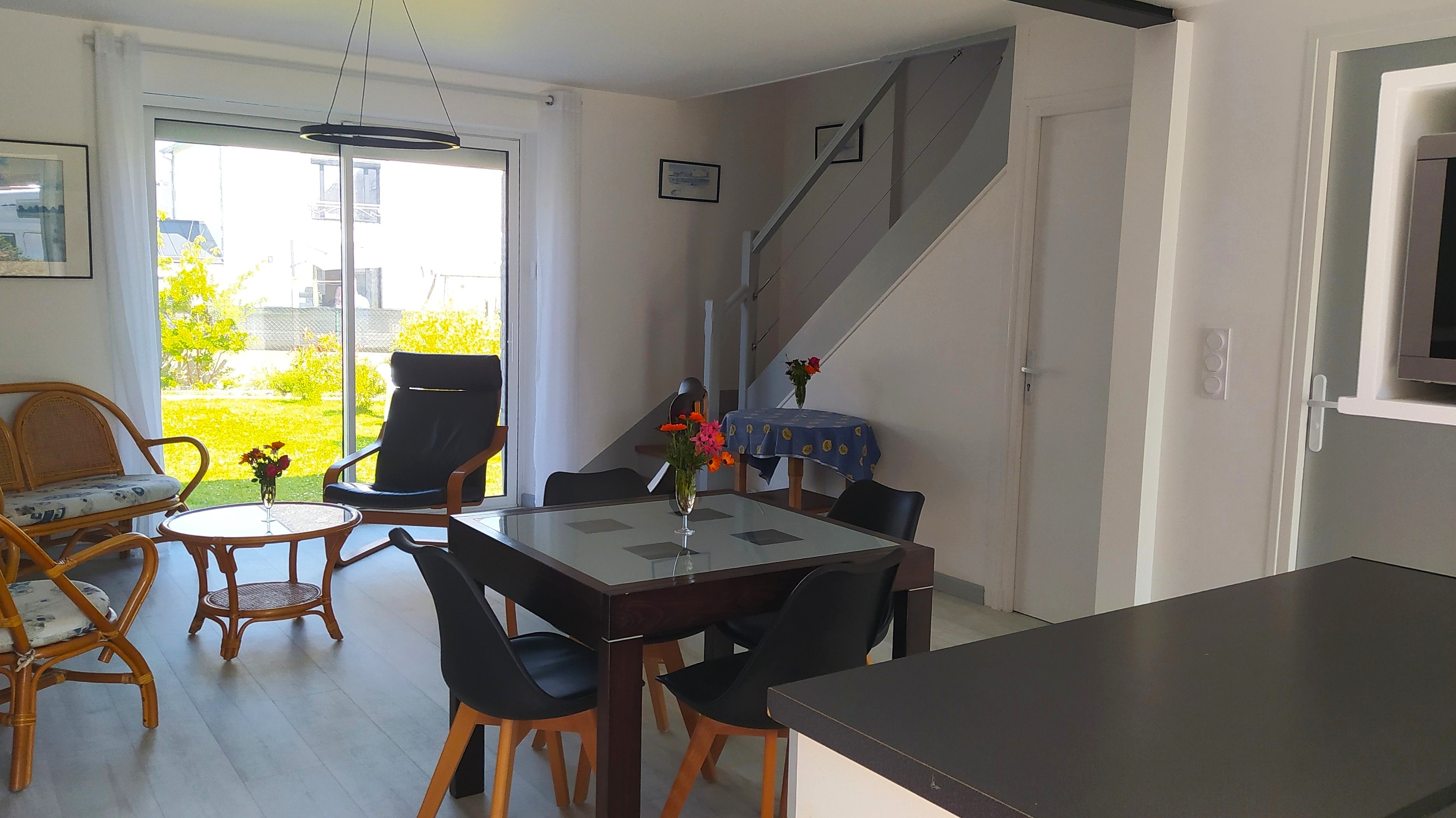 Pièce de vie au RDC avec entrée, cuisine, séjour, salon et poêle à bois.