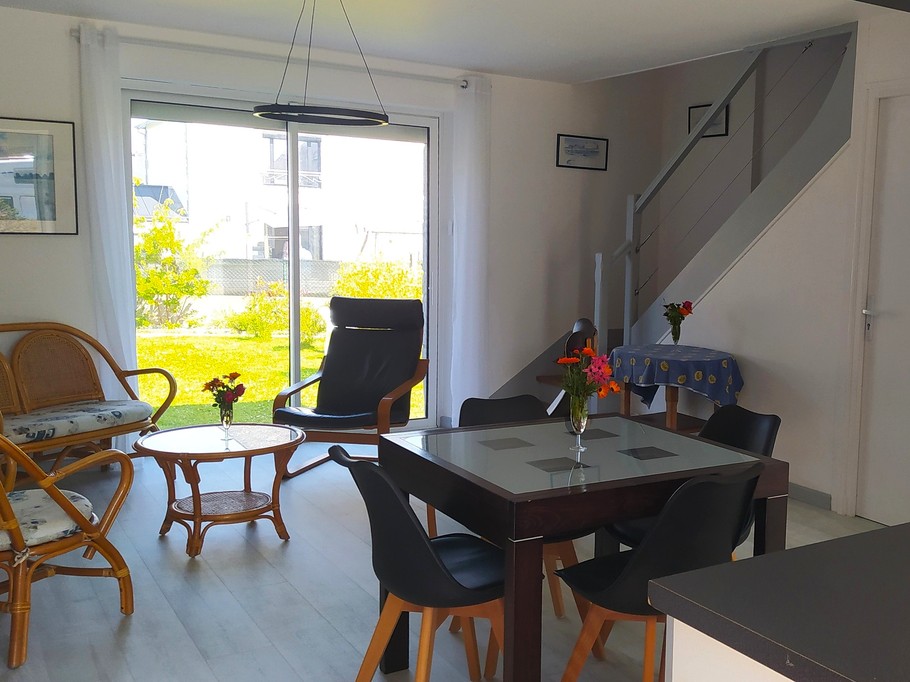 Pièce de vie au RDC avec entrée, cuisine, séjour, salon et poêle à bois.