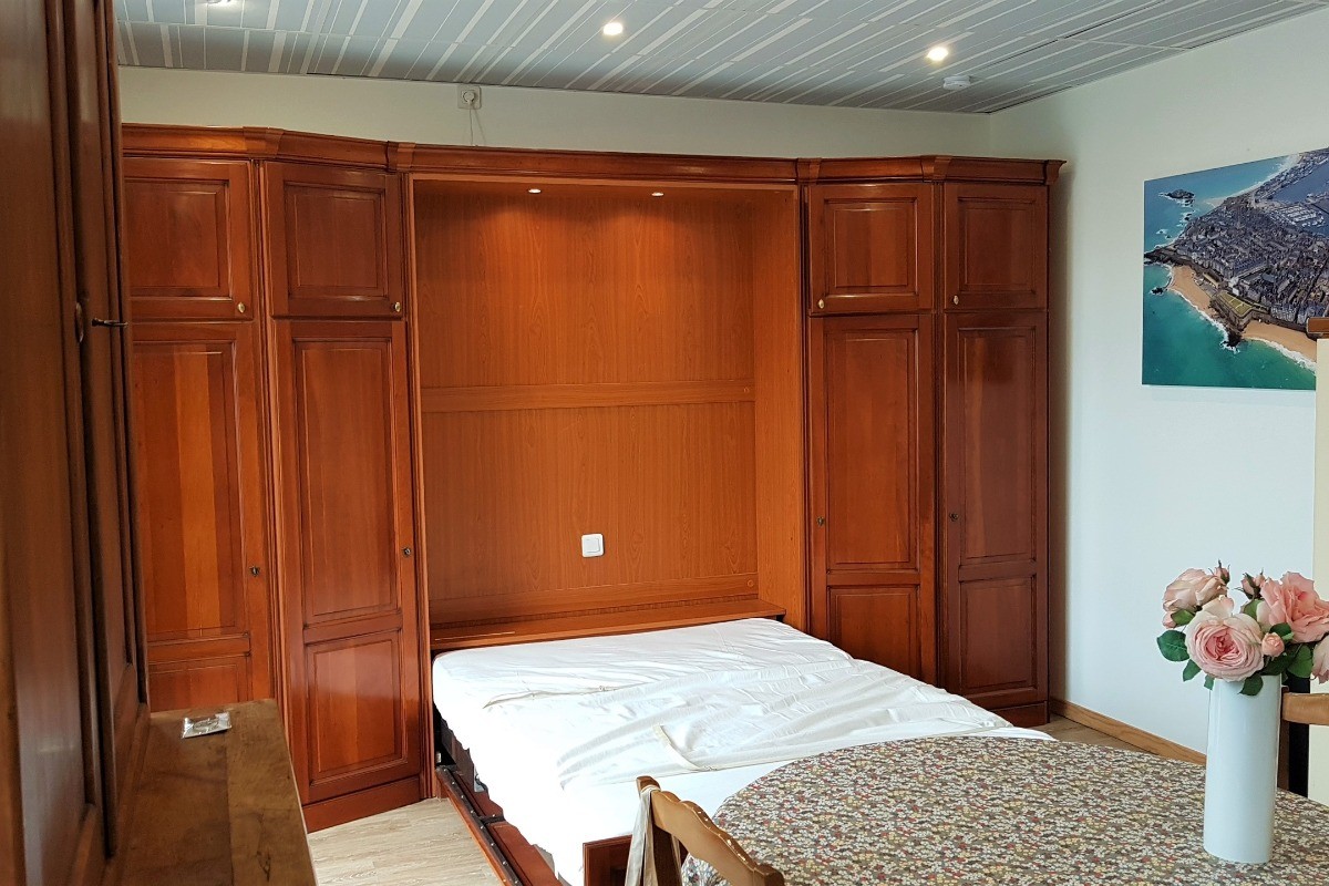 Le coin nuit est un lit confortable pour 2 personnes (140x190cm), élégamment dissimulé dans un dressing le jour.  
Crédits photos : Clévacances 35