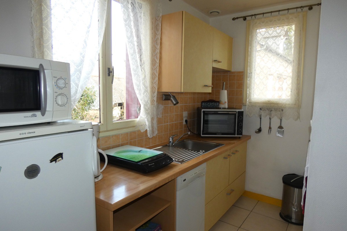 Cuisine bien équipée avec tout le nécessaire de vaisselle, plaque induction, four, micro-ondes, lave-vaisselle, combiné réfrigérateur-congélateur.