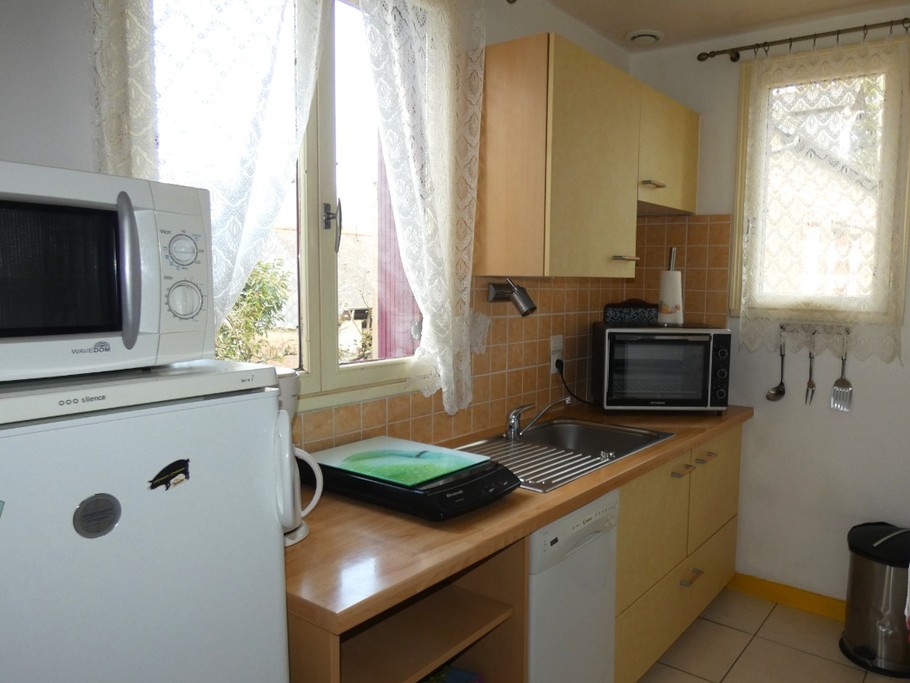 Cuisine bien équipée avec tout le nécessaire de vaisselle, plaque induction, four, micro-ondes, lave-vaisselle, combiné réfrigérateur-congélateur.