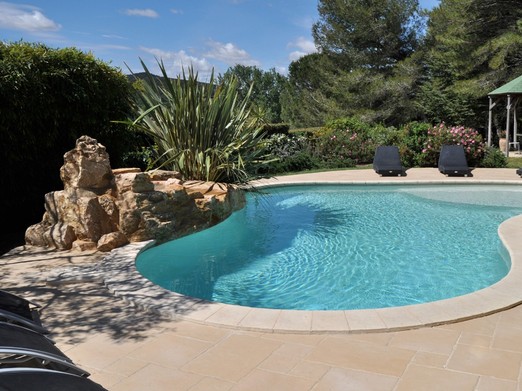 Piscine avec rocher et cascade réalisation haut de gamme Diffazur chauffée par pompe à chaleur