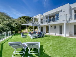 Grande terrasse panoramique au RDC avec salon de jardin et parasol. Cette terrasse donne un accès direct aux 3 chambres et salles de bain du RDC, à la buanderie et au 2 WC séparés.