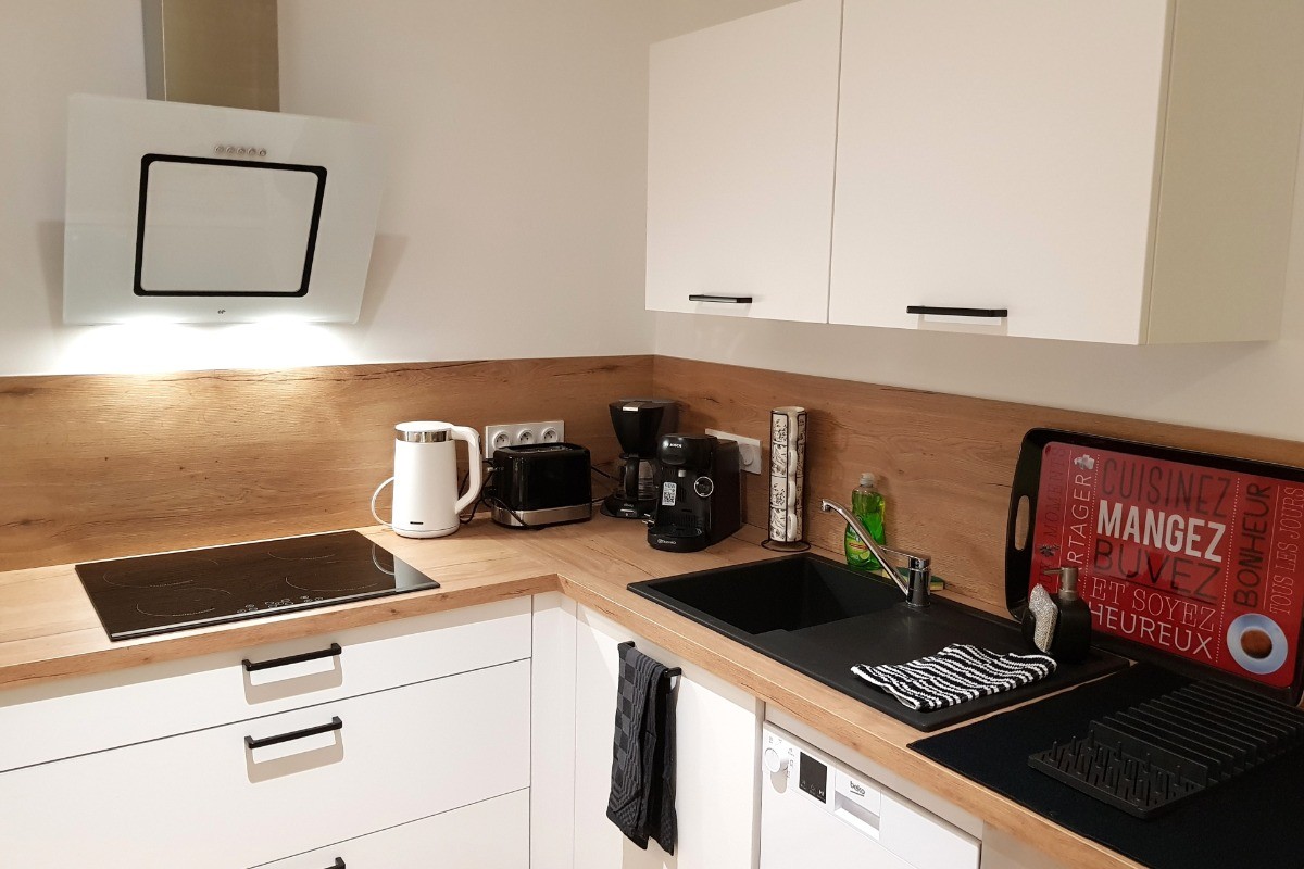 Coin cuisine toute équipée et sa table à manger (lave-vaisselle, four, micro-ondes, combiné-congélation, petits électroménagers, lave-linge, etc.)