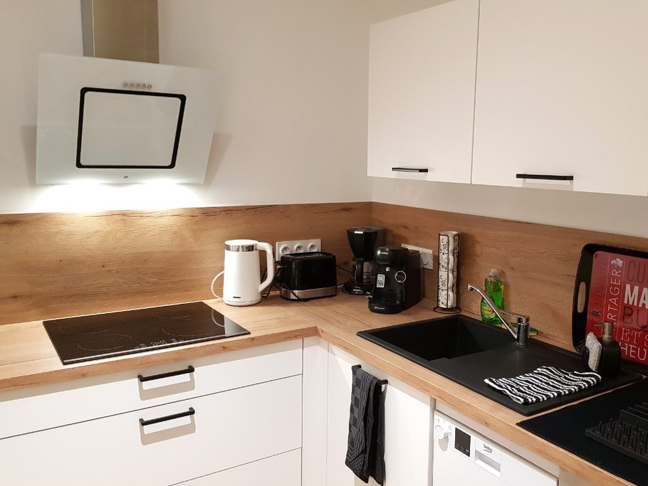 Coin cuisine toute équipée et sa table à manger (lave-vaisselle, four, micro-ondes, combiné-congélation, petits électroménagers, lave-linge, etc.)