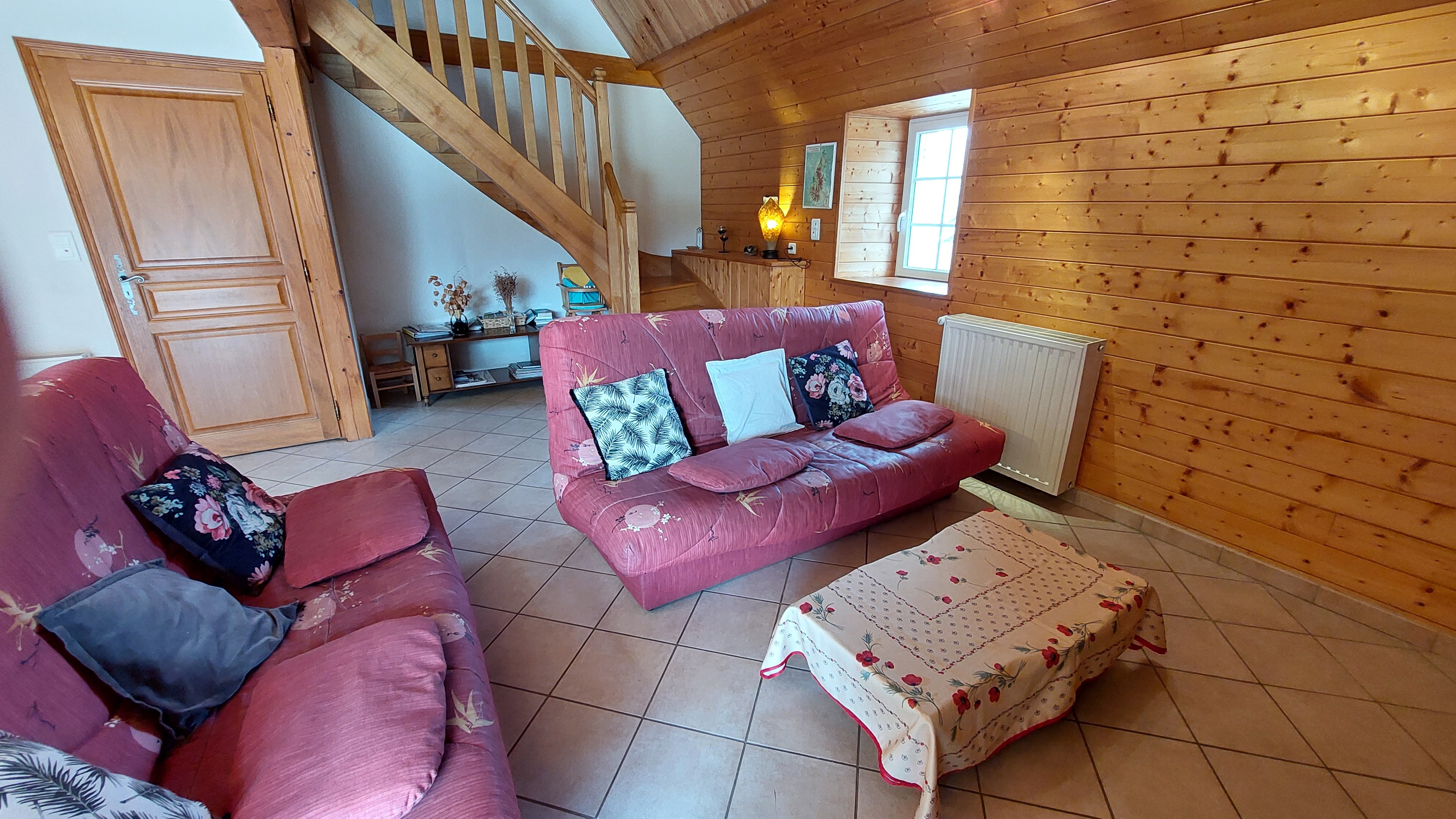 Lounge area with comfortable sofas in a barn converted into a gite at Le Claux