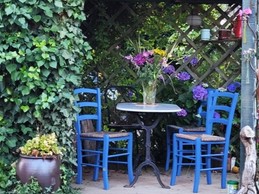 Pergola avec table de jardin dans le grand jardin fleuri et ombragé