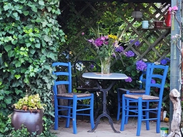 Pergola avec table de jardin dans le grand jardin fleuri et ombragé