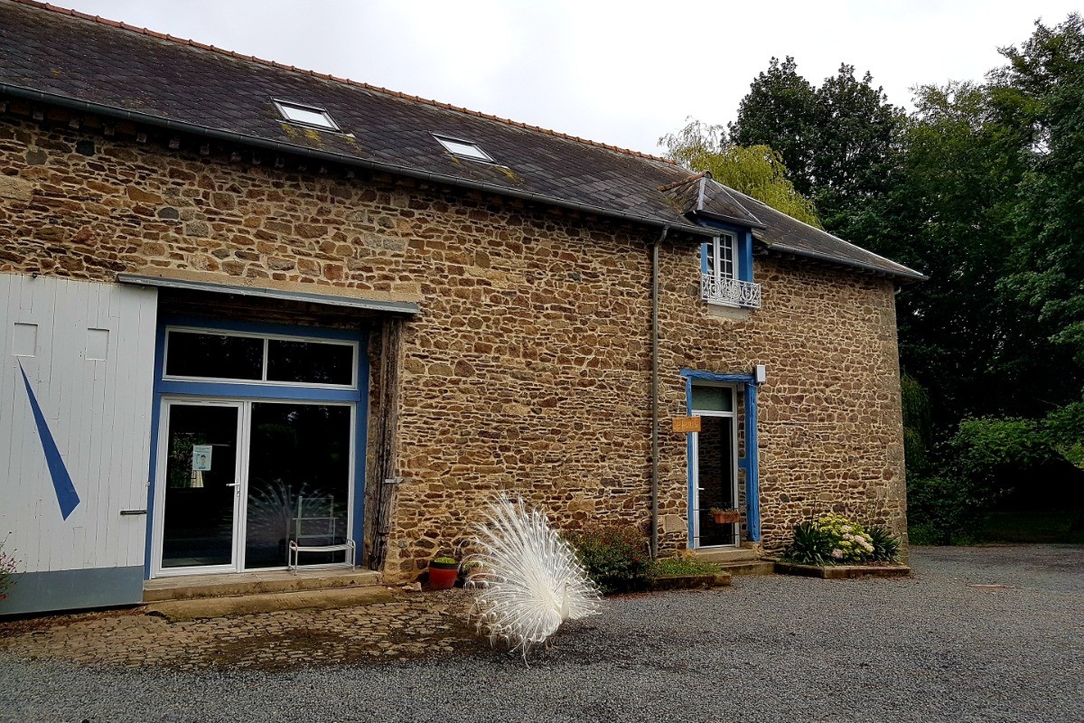 La façade du gîte, une maison en pierres de pays. L'entrée se situe à l'arrière. A gauche de la photo, le local piscine intérieure, commune à une autre gîte.
