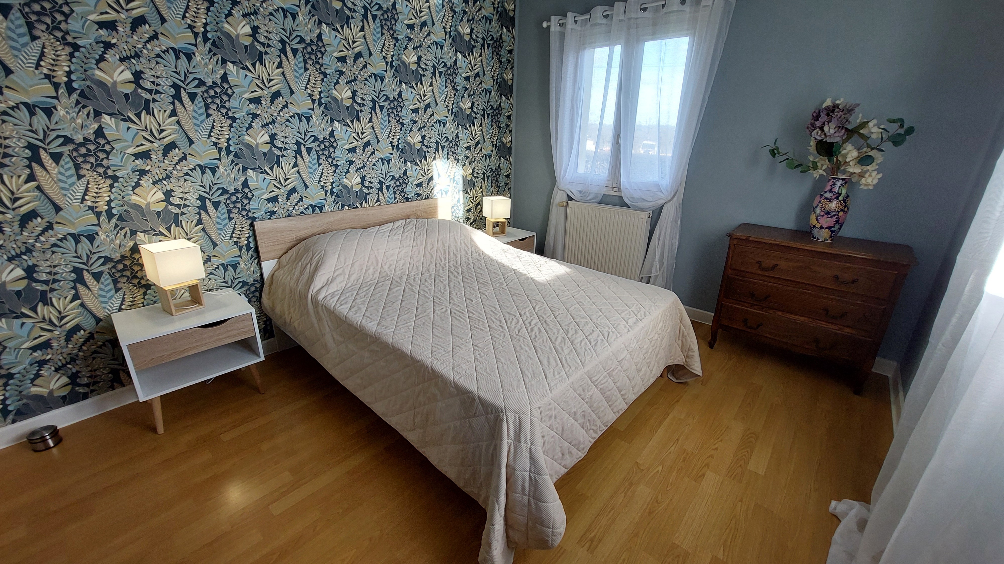 Chambre lumineuse avec lit double et décoration végétale